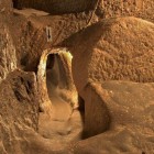 Ozkonak, an underground city in Cappadocia, is a labyrinth of tunnels and rooms carved into the tuff, designed as a safe refuge with ancient defense systems and millennial ingenuity.