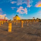 The esplanade of the Mausoleum of Mohammed V in Rabat, with 200 columns from the unfinished 12th-century mosque, houses the Hassan Tower and Moroccan flags.