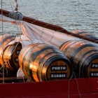 Details of wine barrels being transported by boat on the Douro River in the city of Porto