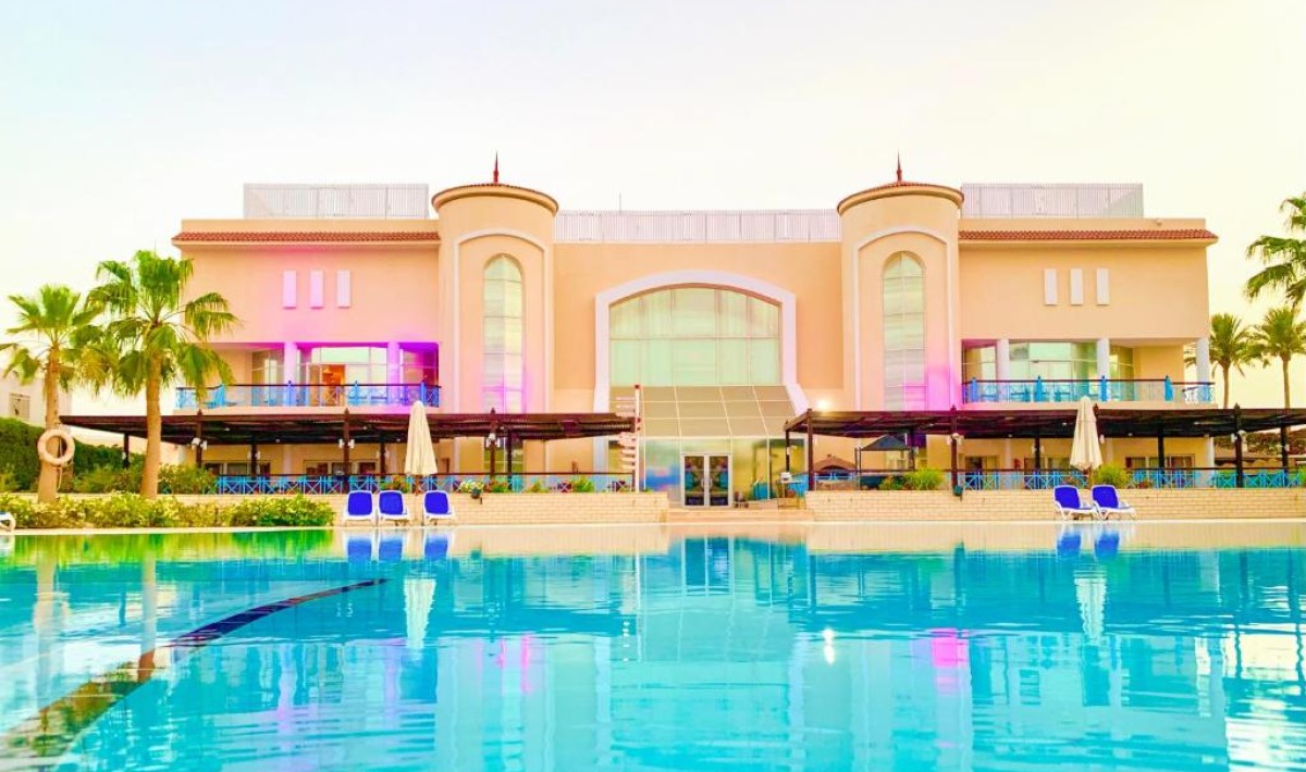 Ivy Cyrene Island Aqua Park Resort - View of the main building overlooking the main pool equipped with sun loungers and umbrellas