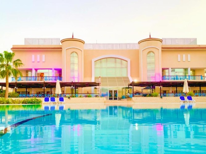 Ivy Cyrene Island Aqua Park Resort - View of the main building overlooking the main pool equipped with sun loungers and umbrellas