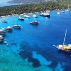 Gulets and boats anchored in the clear waters of Pabuc Bay in the Aegean Sea, Turkey.