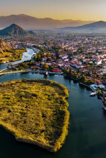 The Dalyan River flows peacefully between mountains and lush vegetation, offering breathtaking views of rock-carved tombs and serene landscapes. Navigating it is a unique experience that blends history and nature