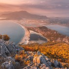 Majestic autumn landscape with a breathtaking aerial panoramic view from Mount Bozburun over Iztuzu Beach, the Dalyan River Delta, and Lake Sulungur at sunset.