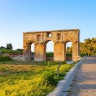 The ancient entrance of Patara, with its imposing Roman monumental arch, welcomes visitors among historic ruins and Mediterranean landscapes, bearing witness to the grandeur of ancient Lycia.