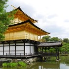 Close-up view of the Golden Pavilion in Kyoto: the golden temple shines under the sun, showcasing the elegance of Japanese architecture amid nature and spirituality.