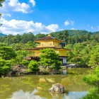 Stunning view of the Golden Pavilion (Kinkaku-ji) in Kyoto, a golden temple surrounded by nature, reflected in a pond that enhances its beauty and the harmony of the Japanese landscape.
