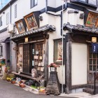 Traditional Japanese wooden restaurant in the quiet and nostalgic Yanaka Ginza district, decorated with religious Ema plaques, symbols of hope and prayer.
