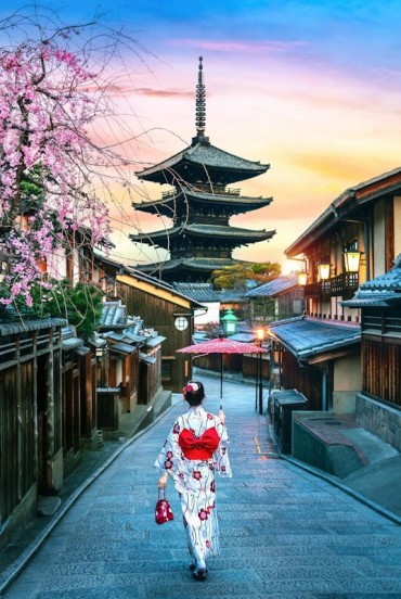 In spring, the Gion district transforms with cherry blossoms. A geisha in kimono walks through the historic alleys, offering an authentic experience of traditional Japanese culture.