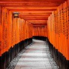 The red torii gates of Fushimi Inari Shrine in Kyoto mark the boundary between the profane and the spiritual world, creating a sacred path leading to the top of Mount Inari.