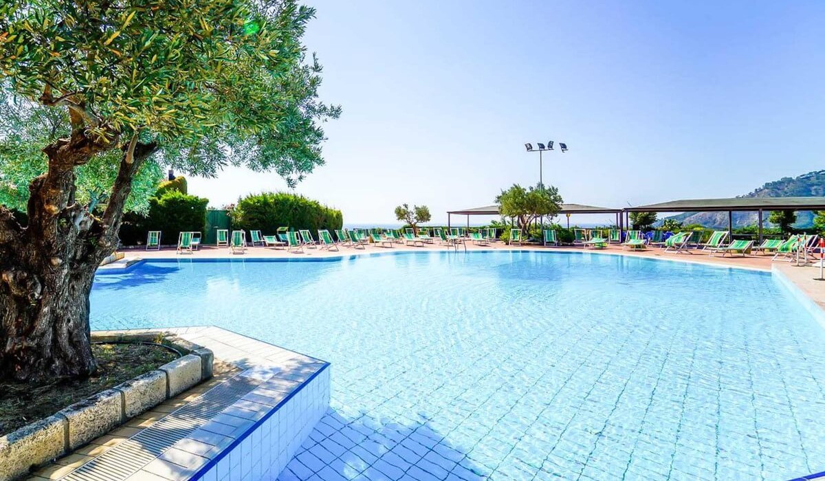 Porto Rhoca Village - Outdoor pool equipped with umbrellas and sunbeds