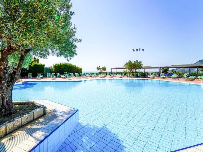 Porto Rhoca Village - Outdoor pool equipped with umbrellas and sunbeds