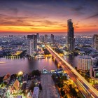 The Bangkok skyline at sunset is one of the most captivating sights of the Thai capital, as golden and pink hues light up the city along the Chao Phraya River and its modern buildings.