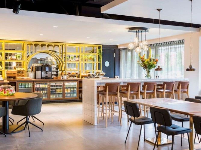 Adagio Amsterdam City South - The breakfast room, featuring an urban design inspired by classic labs, creates a dynamic and relaxing atmosphere. The use of natural materials and natural light minimizes environmental impact.