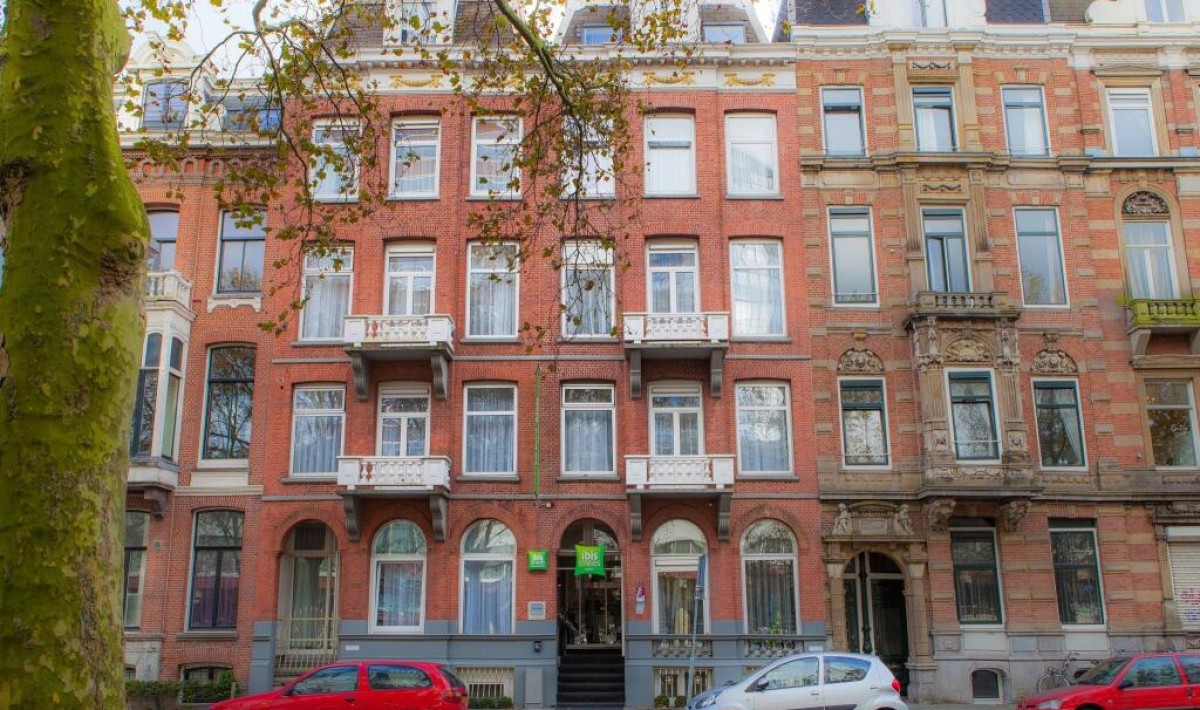 ibis Styles Amsterdam City - 19th-century classic style: the ibis Styles Amsterdam City features red brickwork and an elegant retro atmosphere, with large arched windows on the ground floor framed by decorative moldings and pediments.