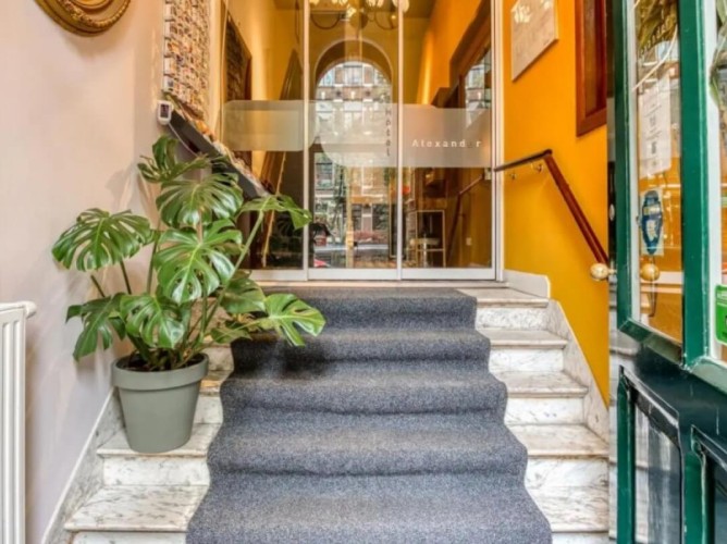 Hotel Alexander - The entrance of Hotel Alexander is simple and elegant, featuring a traditional Dutch façade and a welcoming door that leads into a warm, family-style reception area.