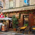 A typical Parisian restaurant on Rue Mouffetard, in the Latin Quarter, welcomes guests with outdoor tables, inviting aromas and the lively atmosphere of Paris’ historic streets.