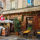 A typical Parisian restaurant on Rue Mouffetard, in the Latin Quarter, welcomes guests with outdoor tables, inviting aromas and the lively atmosphere of Paris’ historic streets.