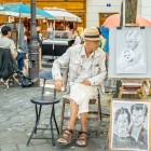 A street caricaturist in Montmartre sketches tourists with quick, ironic strokes. Among easels and colors, his talent captures the soul of Paris' most bohemian district.