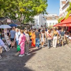 Tourists at the picturesque Place du Tertre: among colorful easels, they stop for a portrait or a caricature, sip coffee on lively terraces, immersed in the vibrant atmosphere.