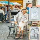 A street caricaturist in Montmartre sketches tourists with quick, ironic strokes. Among easels and colors, his talent captures the soul of Paris' most bohemian district.