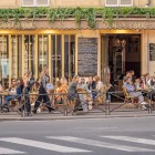 In the lively Pigalle district of Paris, a traditional café welcomes guests at outdoor tables with the typical atmosphere of authentic Parisian bistros.