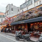 Typical Parisian café decorated with flowers and outdoor seating on Rue des Abbesses, Paris, France.