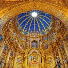 The Virgin of Quito in the main altarpiece of the San Francisco Church and Convent, with blue dome and golden details, in the historic heart of Ecuador’s capital.