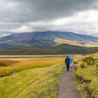 Tourists walking the Limpiopungo lagoon trail in Cotopaxi National Park near Quito, surrounded by Andean landscapes and views of the snow-capped volcano.