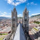 View of the neo-Gothic towers of Quito’s Basilica del Voto Nacional, iconic landmark of the Ecuadorian capital, with the city spreading in the background.