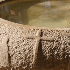 Ancient baptismal font at the Al-Maghtas site, Jordan, the traditional place of Jesus' baptism, surrounded by ruins and historical monuments.