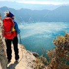A young tourist enjoys the spectacular view of Quilotoa, the green volcanic lake in Ecuador’s Andes, a breathtaking natural wonder of South America.