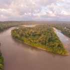 Aerial view of a heart-shaped island on the Napo River, in the Ecuadorian Amazon at dawn. The early morning light illuminates the treetops.