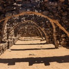 The sturdy vaults of Qasr Azraq, made of basalt stone, showcase Roman and Umayyad defensive engineering in the heart of the desert.
