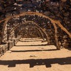 The sturdy vaults of Qasr Azraq, made of basalt stone, showcase Roman and Umayyad defensive engineering in the heart of the desert.