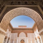 Details of the main entrance of the Ben Youssef Madrasa: a majestic horseshoe arch finely decorated with cedar wood carvings.