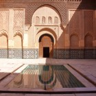 The central courtyard of the Ben Youssef Madrasa houses a large rectangular white marble basin, historically used for ritual ablutions.