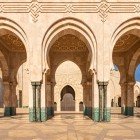 The exterior arches of the Hassan II Mosque showcase intricate mosaics and Islamic patterns, an expression of Moroccan art and unparalleled craftsmanship.