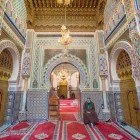 The tomb of Moulay Idriss in Fès houses richly decorated interiors with mosaics, stuccos, and Islamic calligraphy, symbolizing Moroccan faith and art.