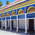 Under the Bahia arcade, hand-carved and painted arches frame geometric zellige mosaics, in a celebration of cobalt blue, green, and ochre.