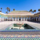 Inner courtyard of the Bahia Palace dominated by a marble fountain, a symbol of Moorish harmony, surrounded by geometric patterns and floral stuccoes.