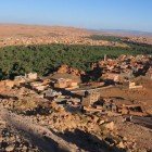 Aerial view of Tinghir with its urban landscape framed by mountains, cultural heart and gateway to the Todra Gorges.