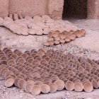 At the Tamgroute ceramics workshop, outside you can see unpainted plates and vases arranged in the sun, awaiting the traditional green glazing.