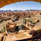 The view from above Nkob reveals a network of red-earth kasbahs among palm groves and arid hills, with Jbel Saghro dominating the horizon.