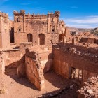 The exterior of the Kasbah of Telouet dominates the High Atlas with its rammed-earth walls, imposing towers, and spectacular views along the ancient caravan routes.