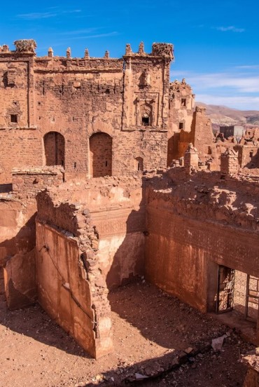 In Telouet, the ruins of the kasbah offer glimpses of Berber architecture among collapsed courtyards and decorated walls, symbolizing an imperial past.
