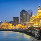 Night view of Shanghai’s Bund, with illuminated historic buildings and reflections on the Huangpu River creating a stunning panorama.