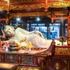 The Reclining Jade Buddha statue in the Shanghai Temple represents serenity and enlightenment, a masterpiece of Chinese Buddhist tradition.