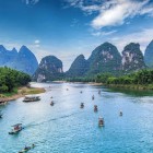 Small tourist boats on the Li River in Guilin, among karst mountains and traditional villages, offer authentic views of southern China.