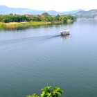 Cruise on Hué’s Perfume River, famous for waters scented by seasonal flowers, among historic bridges, temples, and imperial panoramas.